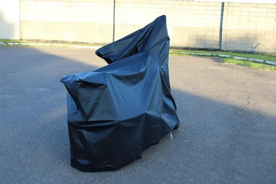 Imagem lateral de motocicletas com fundo externo, piso asfaltado e parede de tijolos. Imagem lateral de motocicletas com fundo externo, piso asfaltado e parede de tijolos.