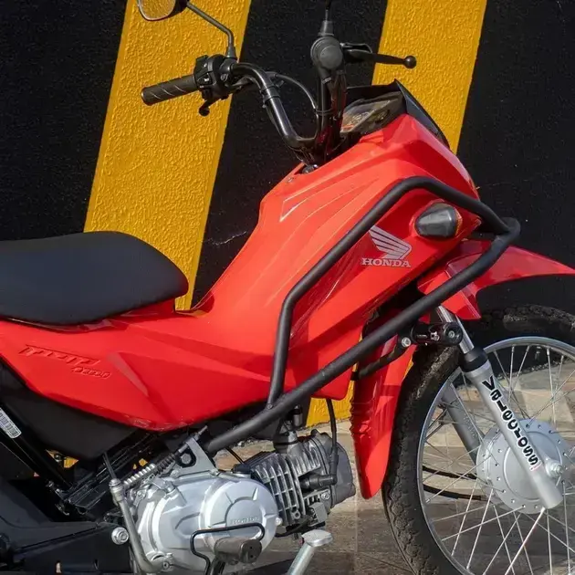 Motocicleta lateral com fundo em cores preto e amarelo, criando um contraste com a motocicleta vermelha.